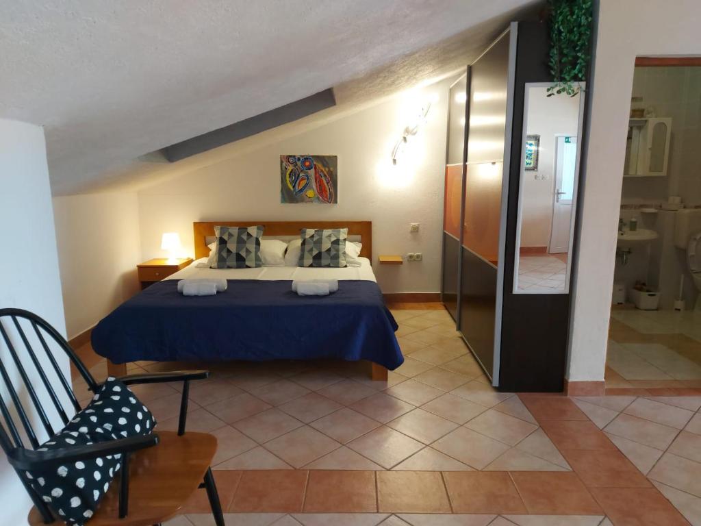 a bedroom with a bed and a chair in a room at Apartman studio Dino Klimno in Klimno