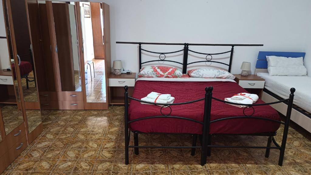 a bedroom with a bed with a red bedspread at Villetta Scolacium in Roccelletta