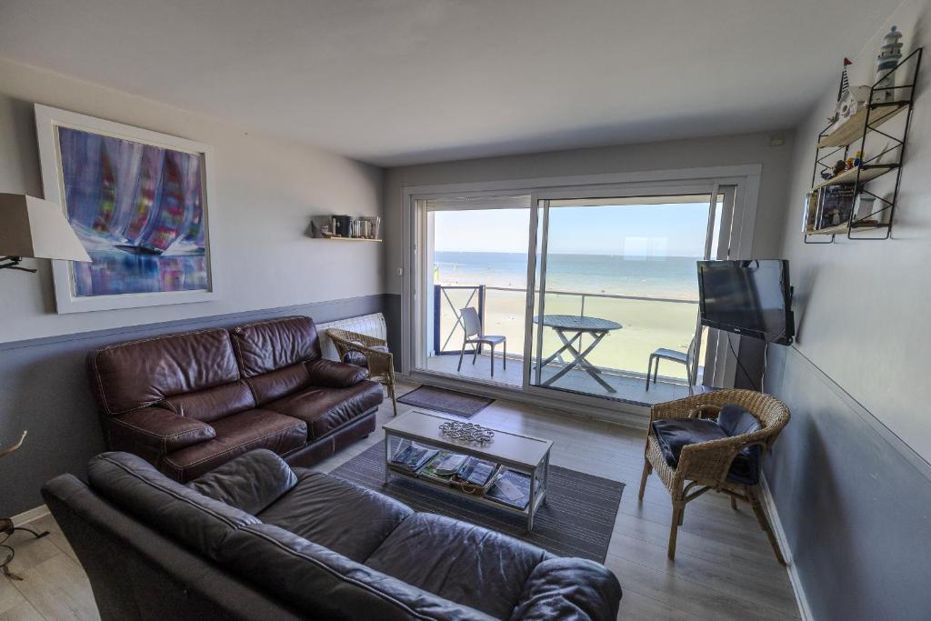- un salon avec un canapé et une télévision avec vue dans l'établissement Le Grand Bleu, à Wimereux