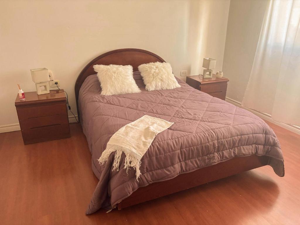 ein Schlafzimmer mit einem großen Bett mit zwei Nachttischen in der Unterkunft Alma Patagónica, Tu Departamento en el Centro in Trelew