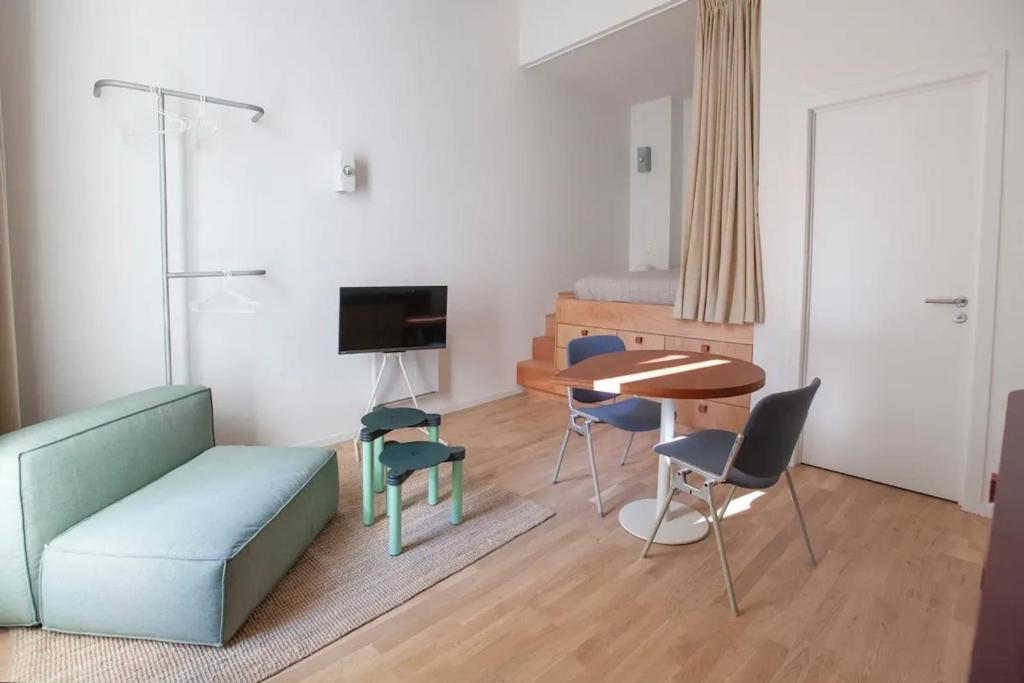 ブリュッセルにあるApartment with City View in Saint-Gilles, 80 m²のソファとテーブルとベッドのあるリビングルーム