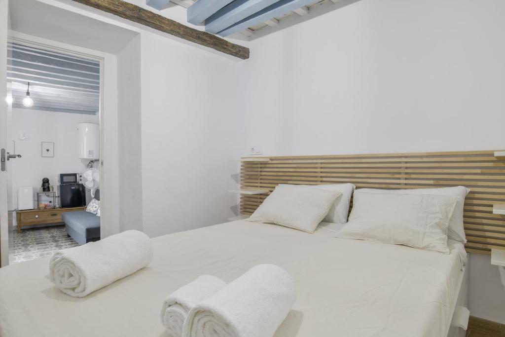 a white bedroom with a large white bed with white pillows at Casita Luna in Vejer de la Frontera