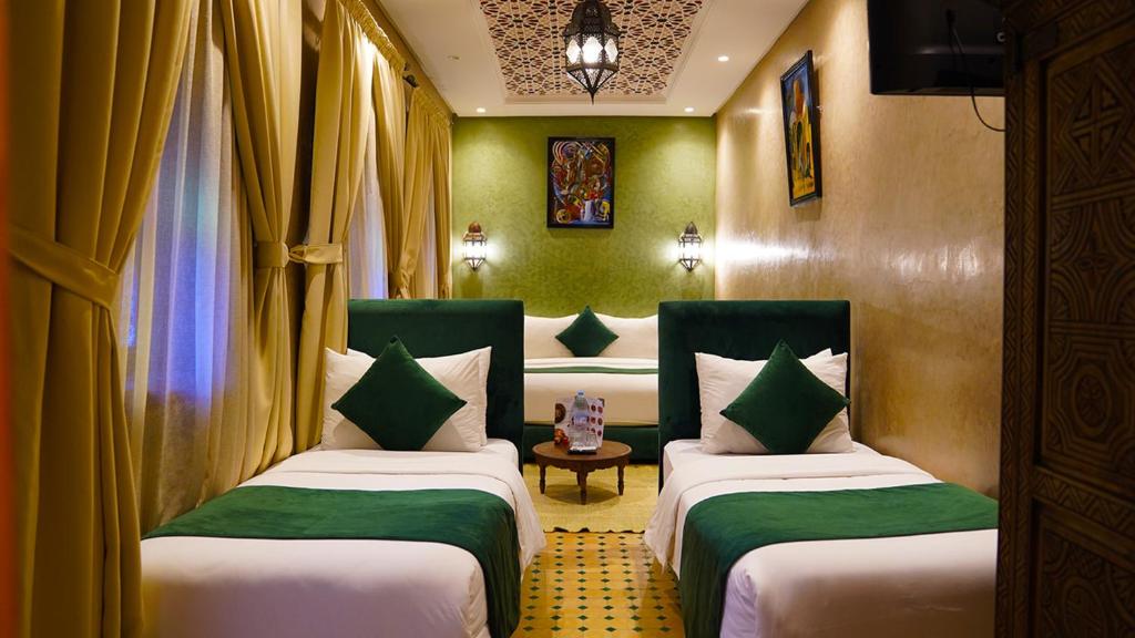 - 2 lits dans une chambre avec des murs et des rideaux verts dans l'établissement Riad Touhfa Kasbah Marrakech, à Marrakech