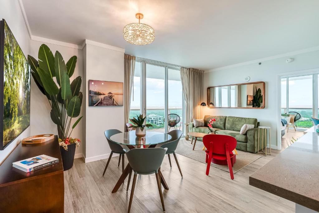 a living room with a table and chairs and a couch at Modern 3BR 3BA Grove Condo Views Balconies Full Kitchen 3 Parking in Miami