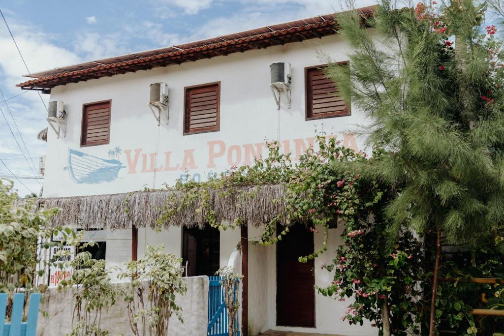 a white building with a sign that reads villa pomongo at Pousada Villa Pontinha in Icaraí