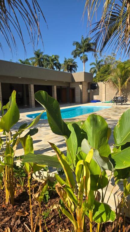 a resort with a swimming pool and some plants at Chácara Recanto dos Pássaros 04 in Olímpia