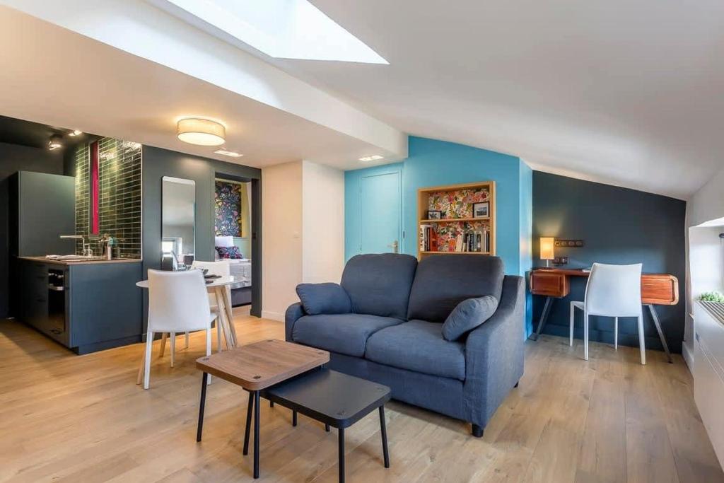 un salon avec un canapé bleu et une table dans l'établissement Garet - Furnished apartment - Downtown Lyon, à Lyon