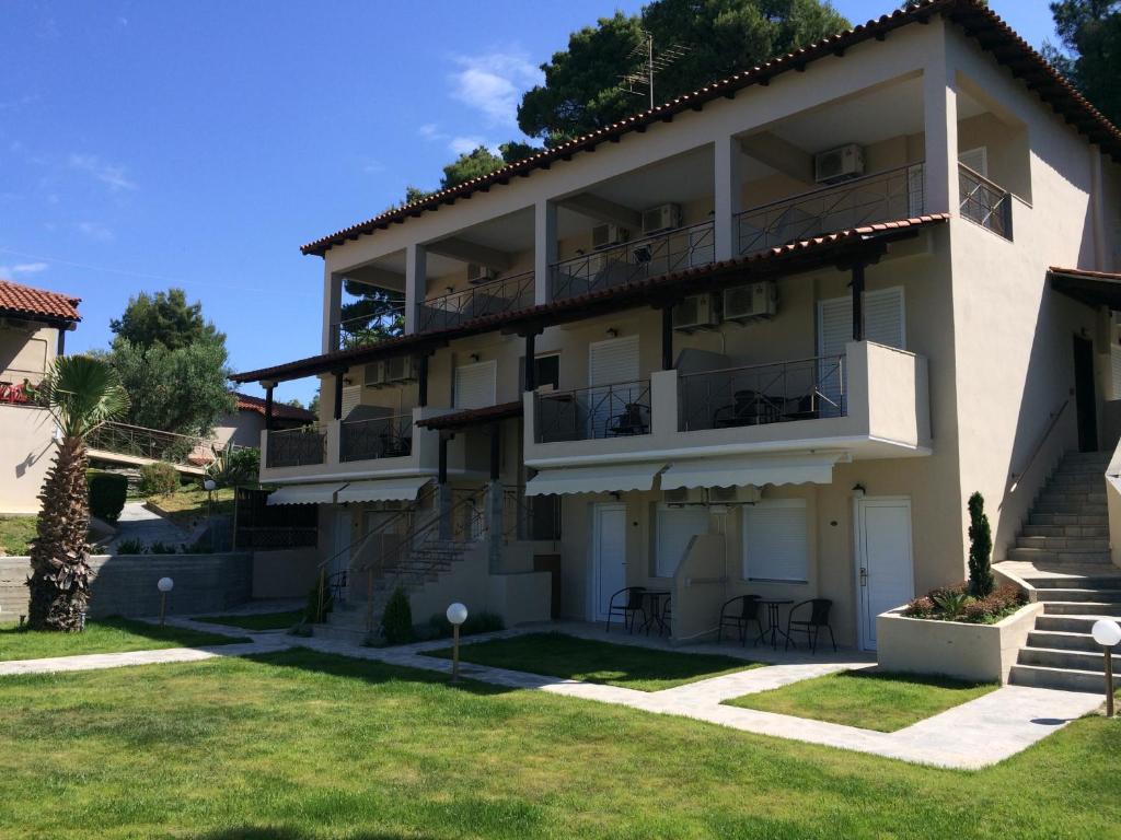 a large apartment building with a lawn in front of it at Thea Hotel in Possidi