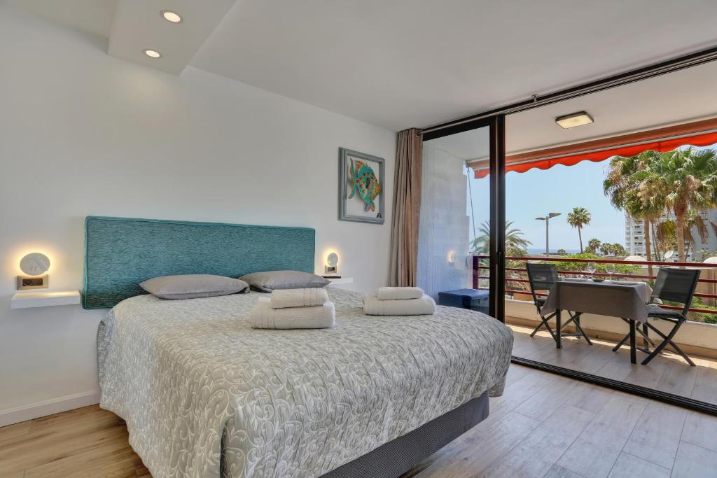 Un dormitorio con una cama grande y un balcón. en Sunset Tenerife, en Playa de las Américas