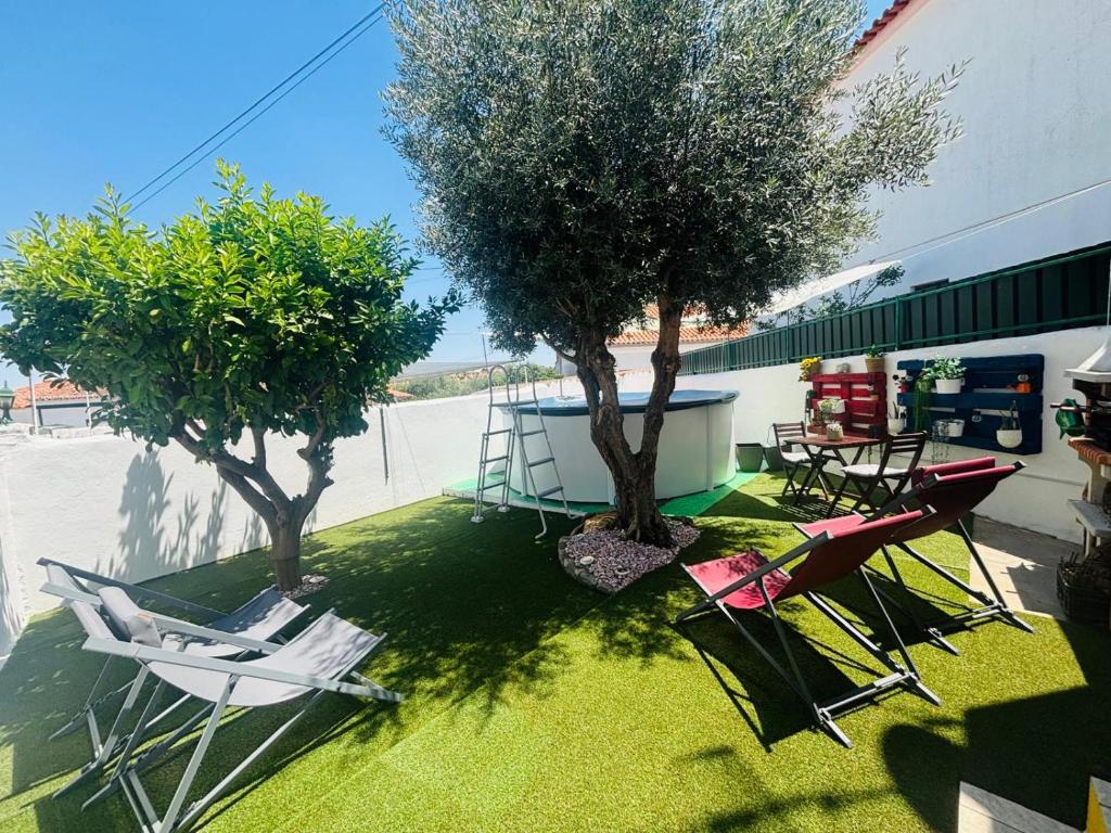 a group of chairs and trees in a yard at Casa D' Oliveira in Castro Verde