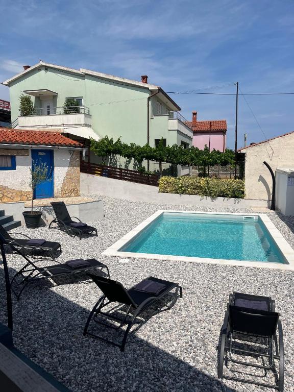 a swimming pool with lounge chairs and a house at Manolo house with jacuzzi & pool in Pula