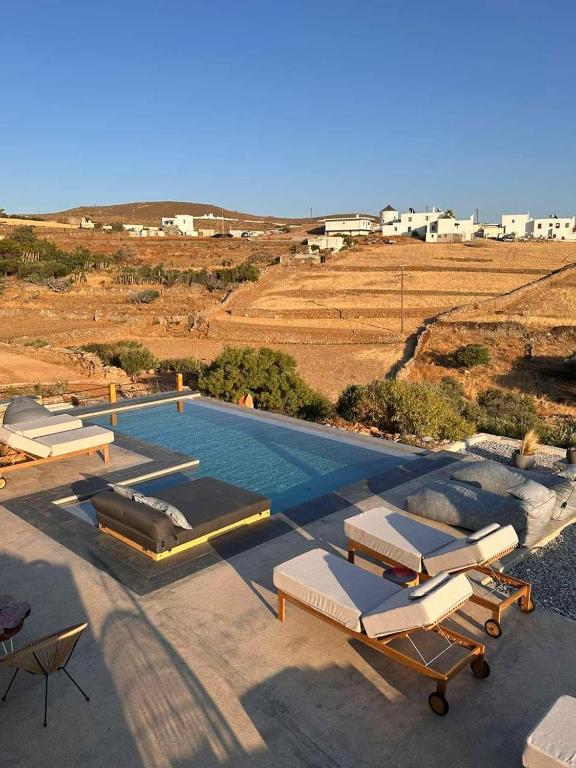a swimming pool with chaise lounge chairs and a swimming pool at Kozadinos Art Suites in Kithnos