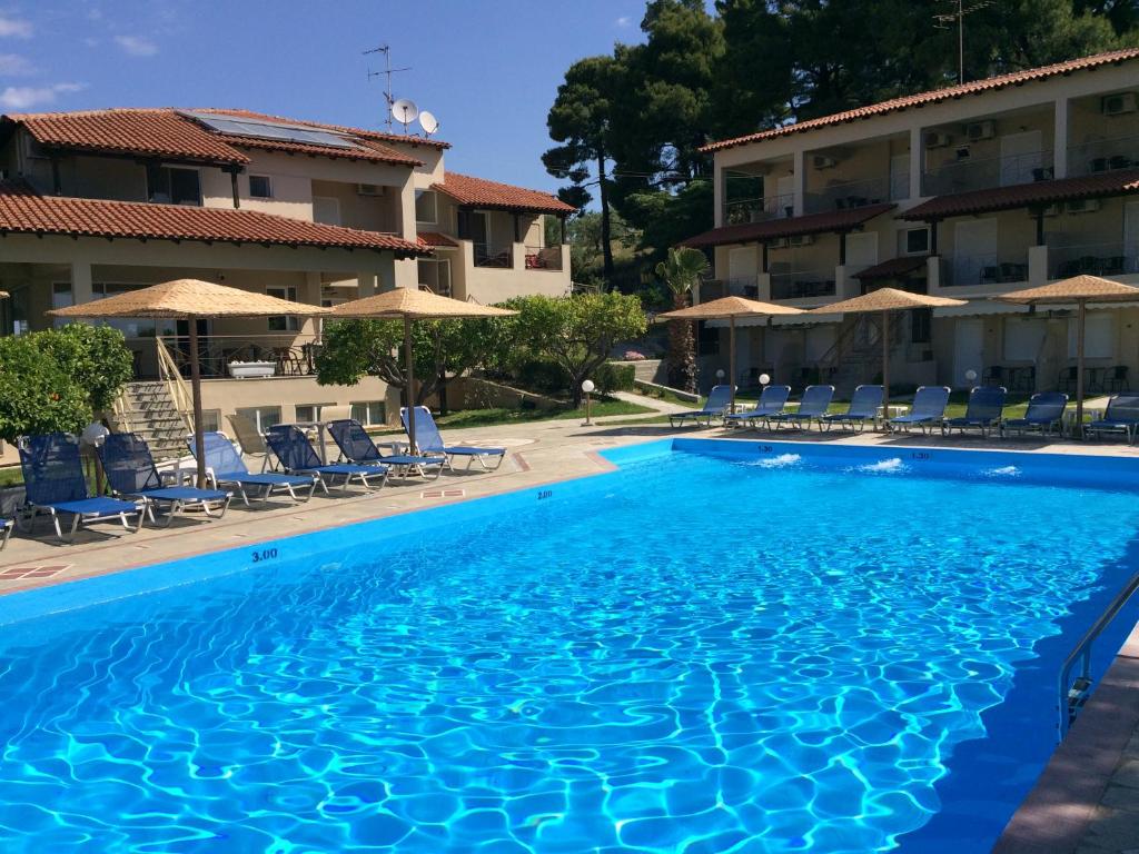a swimming pool in front of a hotel at Thea Hotel in Possidi