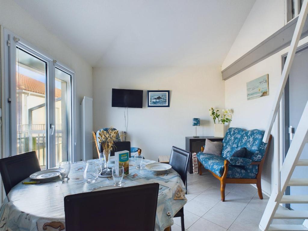 une salle à manger avec une table et une chaise dans l'établissement Appartement coquet avec vue sur mer, à Saint-Hilaire-de-Riez