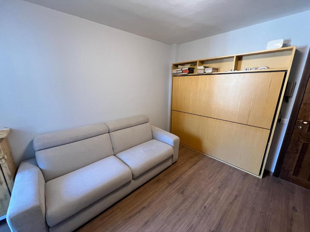 a living room with a couch and a closet at Aurora Boreale studio - centro Aprica - parking in Aprica