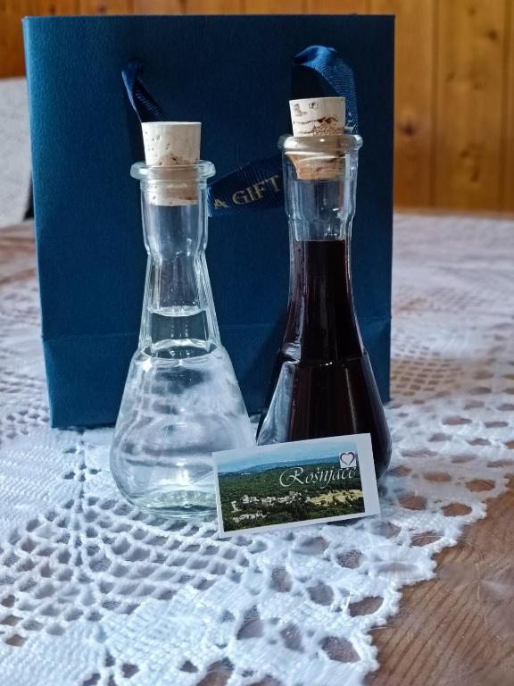 two glass bottles sitting on top of a table at Village House Rošnjače in Tomislavgrad