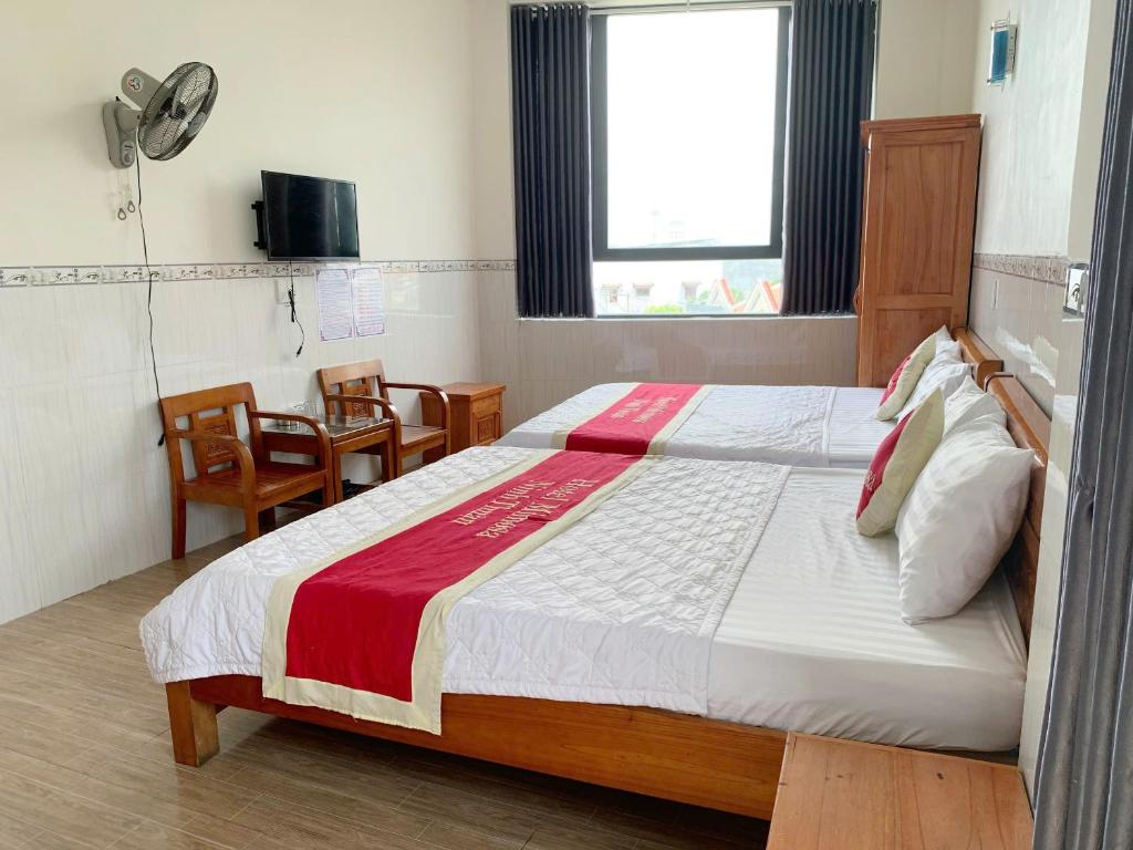 une chambre avec un lit, une table et des chaises dans l'établissement Hotel Mimosa 2, à Phan Rang