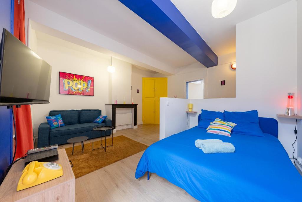 Un dormitorio con una cama azul y un sofá. en Pop'Arras - Studio Hyper centre d'arras, en Arras
