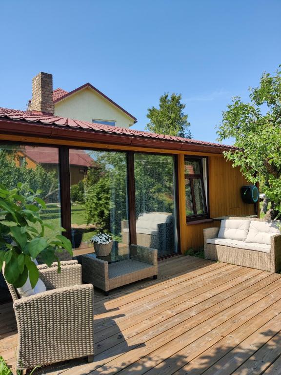a deck with glass doors and furniture on it at Namiņš AMRAI in Ventspils