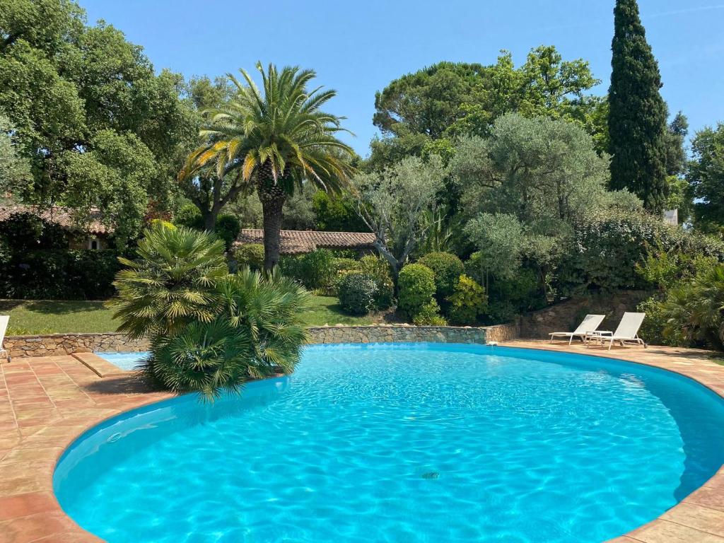 una piscina blu in un cortile con alberi di Bergerie a Grimaud