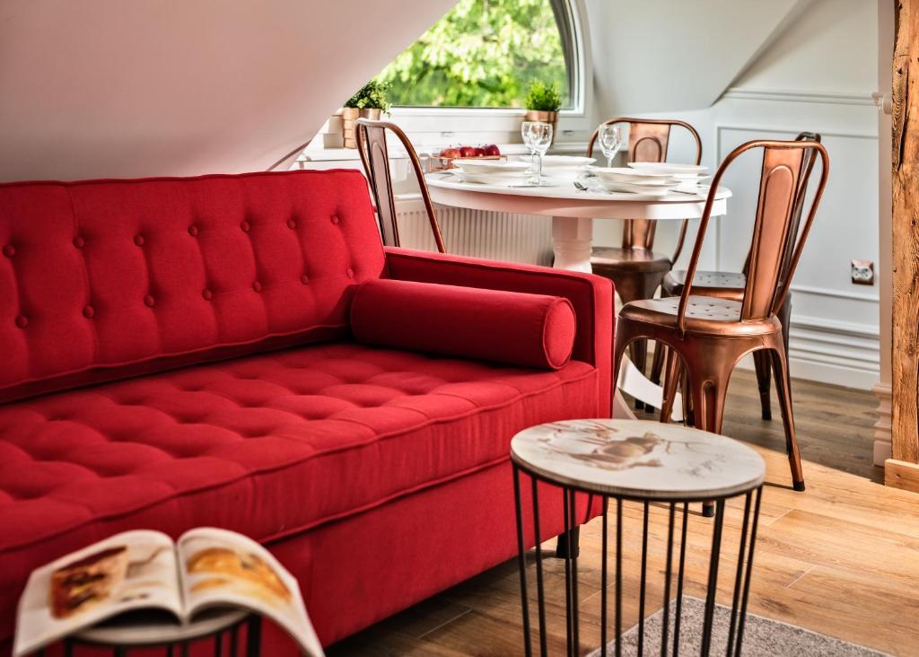 salon z czerwoną kanapą i stołami w obiekcie Lion Apartments - CHILLSET Apartmenty Westerplatte w mieście Sopot
