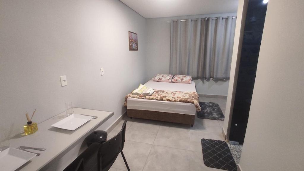 ein kleines Zimmer mit zwei Betten und einem Schreibtisch in der Unterkunft Kitnet independente confortável e muito bem localizada in Belo Horizonte