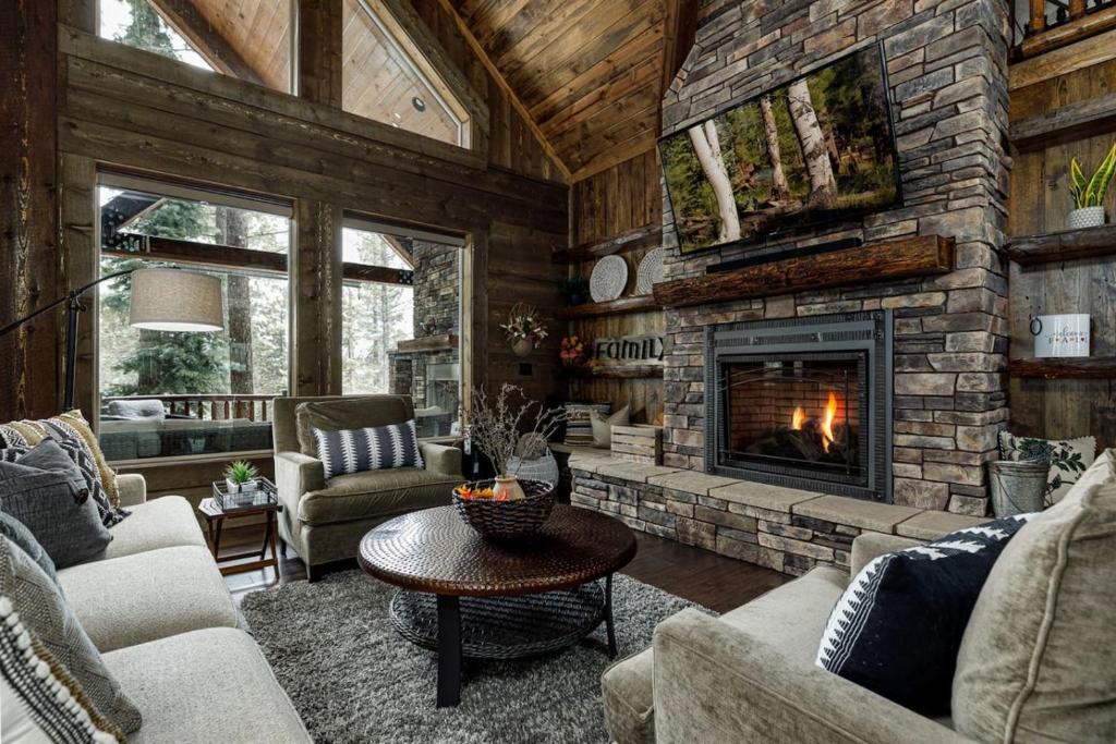 a living room with a stone fireplace in a house at Mossberg Luxury Retreat in Duck Creek Village