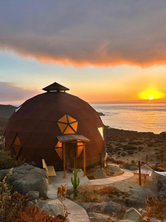 a dome house with a sunset in the background at DomoChango in La Serena