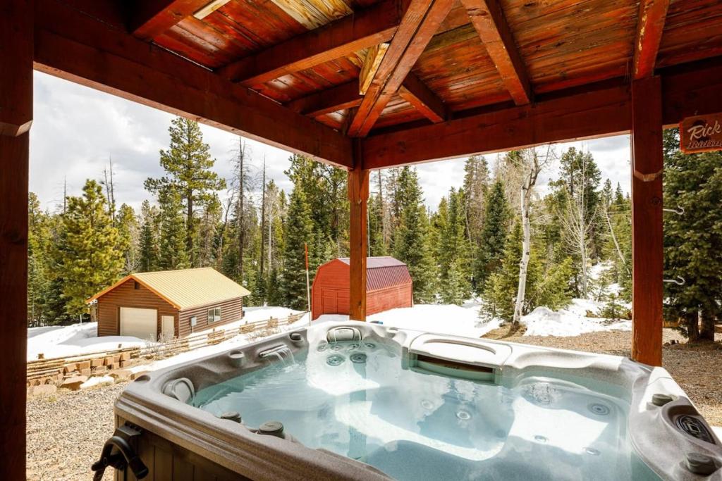 una vasca idromassaggio su una terrazza nella neve di Pine View Cabin Retreat, Hot Tub, Walk Out Patio a Duck Creek Village