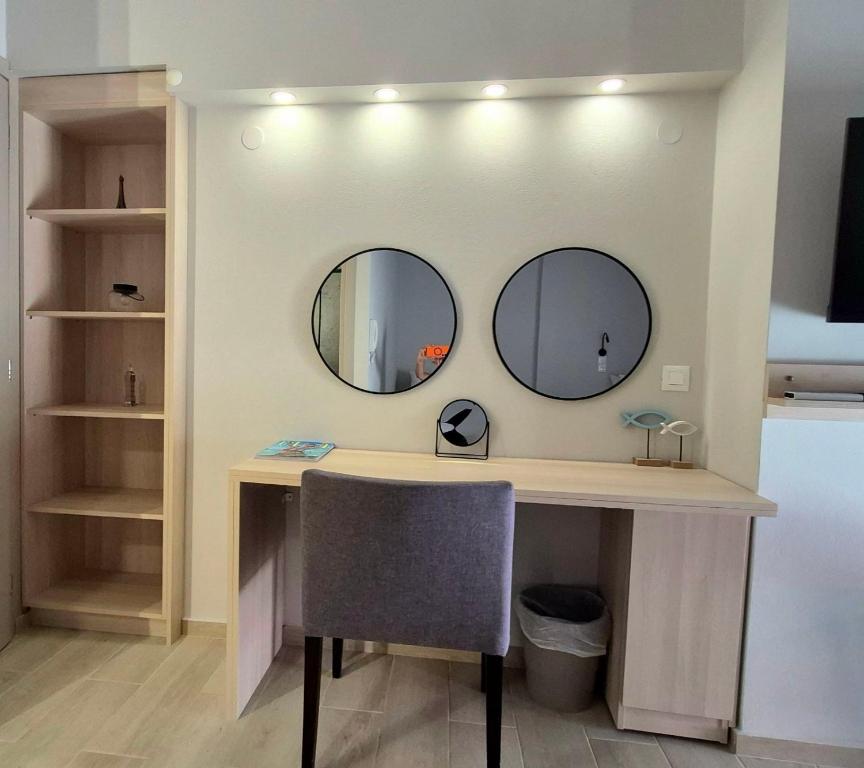 a desk with two mirrors on a wall with a chair at SITIA CITY CENTER modern apartment in Sitia
