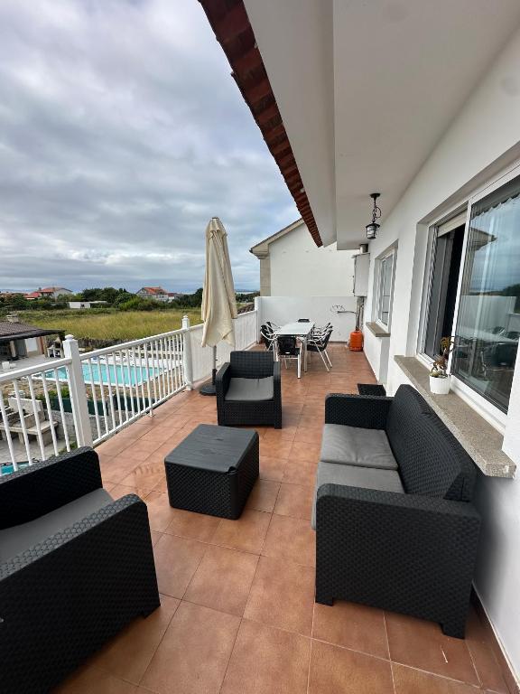 a patio with couches and a table and a umbrella at CASA Nieves in O Grove