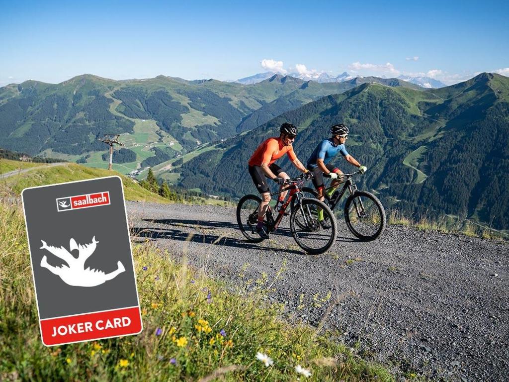 two people riding bikes on a mountain road at Hotel Eder Michaela in Saalbach-Hinterglemm