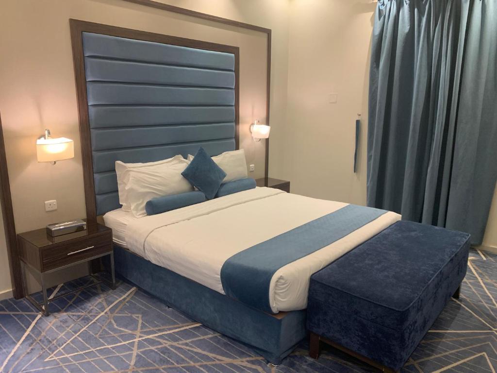 a bedroom with a large bed with a blue headboard at القصر الضيافة 2 in Khamis Mushayt