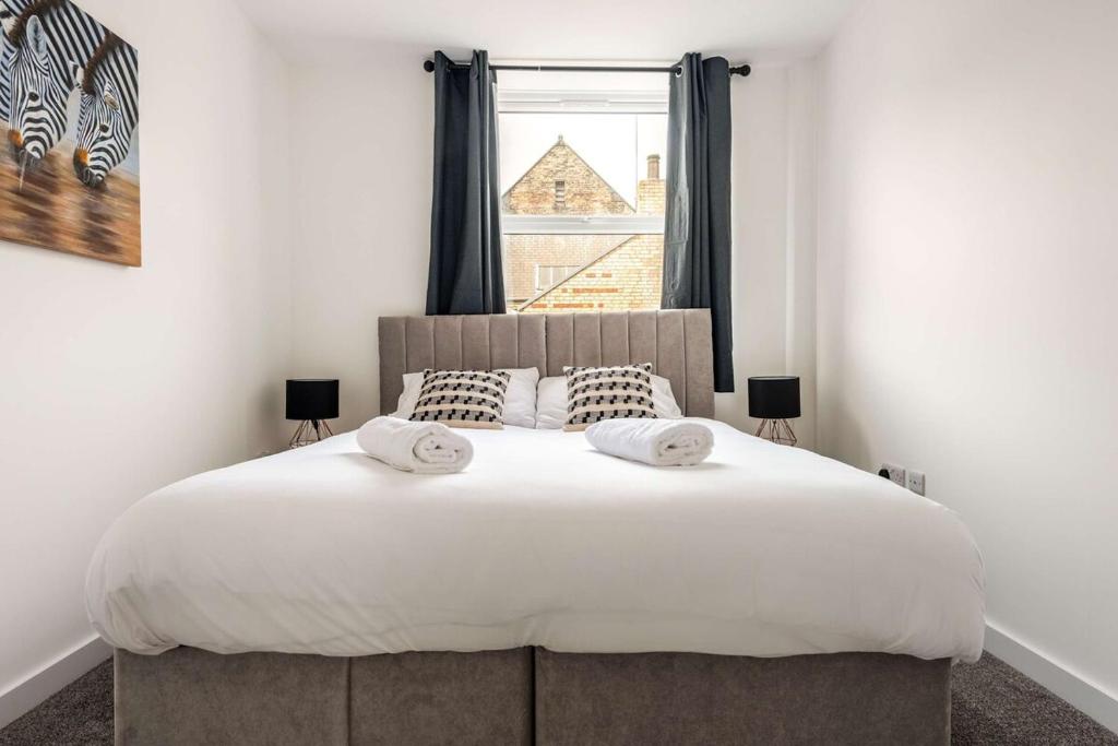 ハルにあるHull City Centre Sleeps 4 Free Parkingの窓のある大きな白いベッドのある寝室