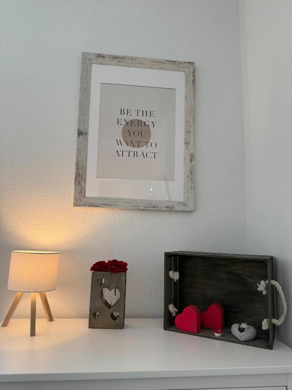 a picture above a table with a lamp and a picture at Basseltang urban apartment in Grenzach-Wyhlen