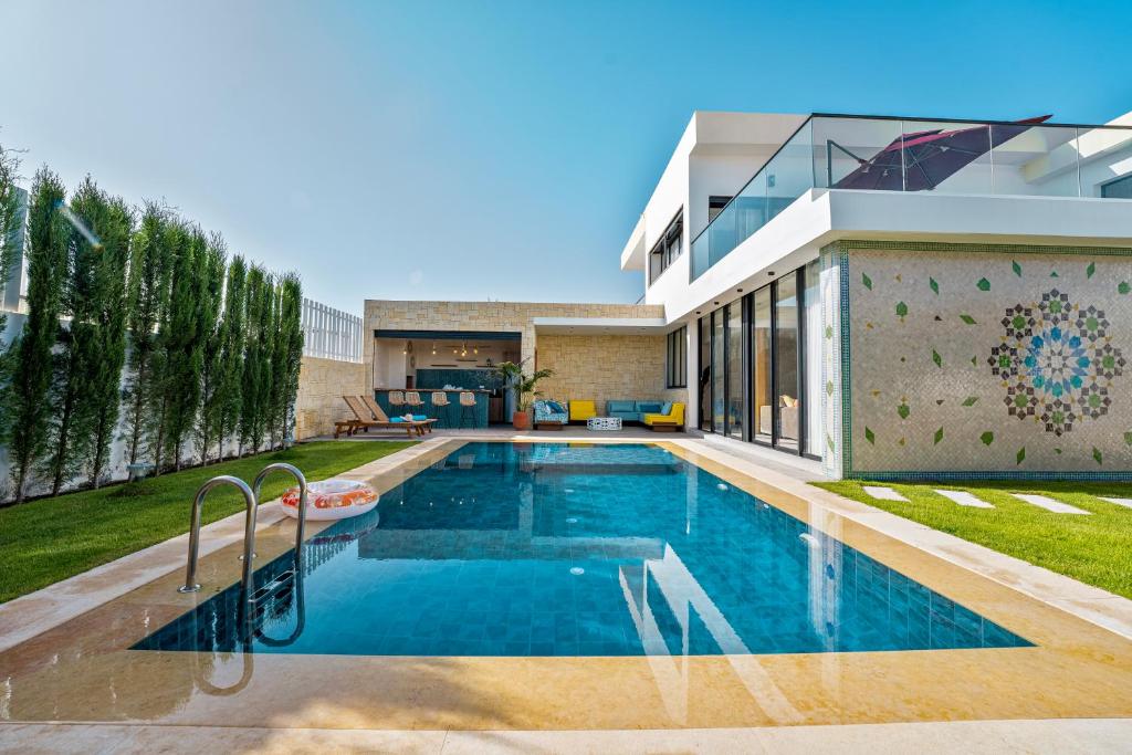 a swimming pool in front of a house at Luxury Villa Heated Pool Taghazout Bay in Tamraght Ouzdar