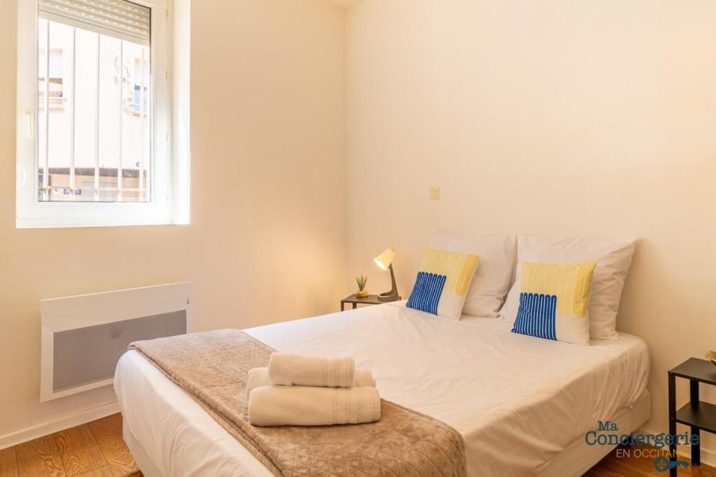 une chambre avec un grand lit blanc avec une fenêtre dans l'établissement Grece - centre ville - proche des commodités, à Toulouse