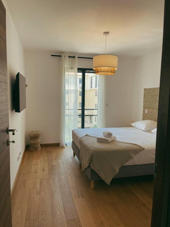 une chambre avec un lit et une grande fenêtre dans l'établissement Bel Appartement Vieux Port Porto-Vecchio, à Porto-Vecchio