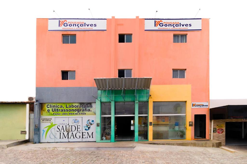 a large orange building with a store front at Pousada Gonçalves in Tangará