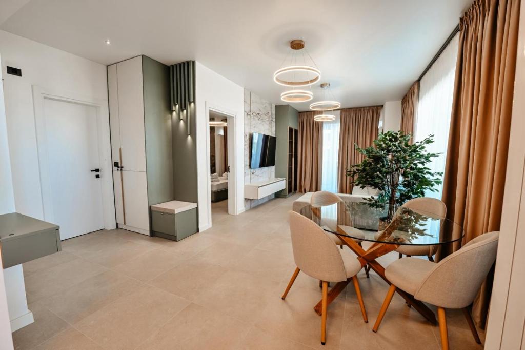 a living room with a glass table and chairs at Odyssey Sea-View Apartament in Mamaia Nord