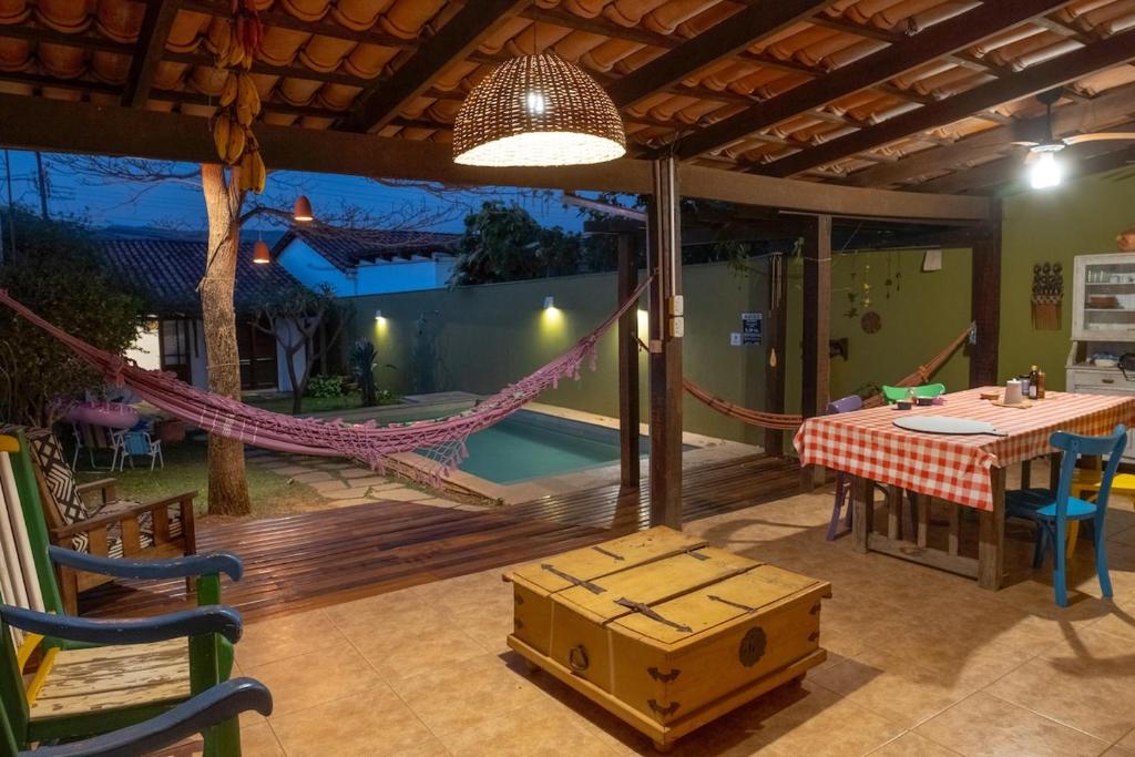 a patio with a hammock and a table and chairs at Comfort in the center of Piri - Casa Ipê Branco in Pirenópolis