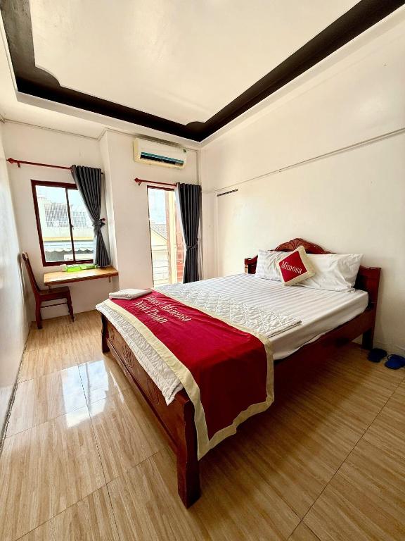 a bedroom with a large bed in a room at Mimosa 2 Hotel - Phan Rang in Phan Rang–Tháp Chàm