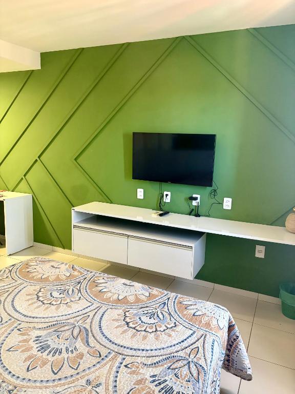 a bedroom with a flat screen tv on a green wall at Smart Residence flat 803 in Teresina