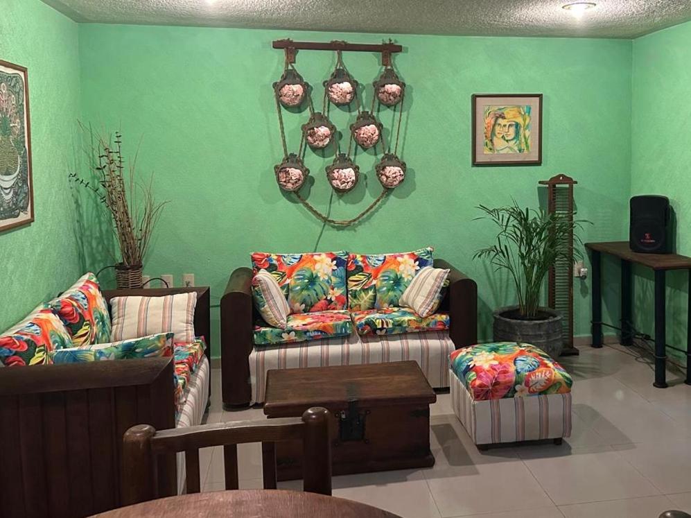 a living room with two couches and a green wall at Rincón de Checo in Mexico City