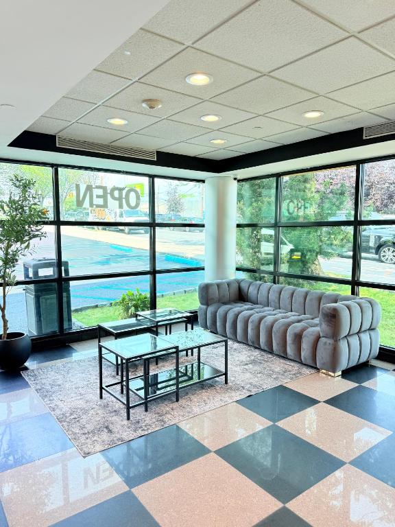 a lobby with a couch and a table and windows at Nova Hotel Bronx in Melrose