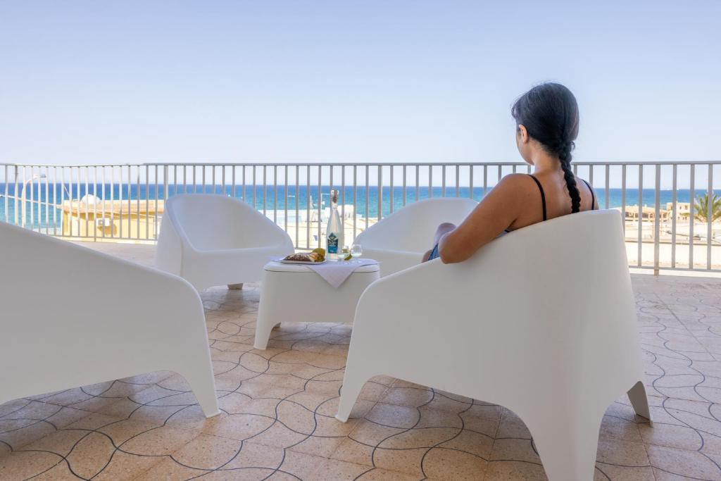 Una donna seduta su una sedia che guarda l'oceano di Casa Liliana 1 a Cava dʼAliga