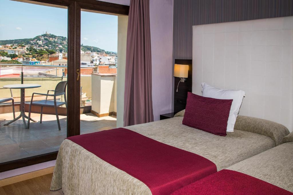a hotel room with a bed and a balcony at Petit Palau - Adults Only in Blanes