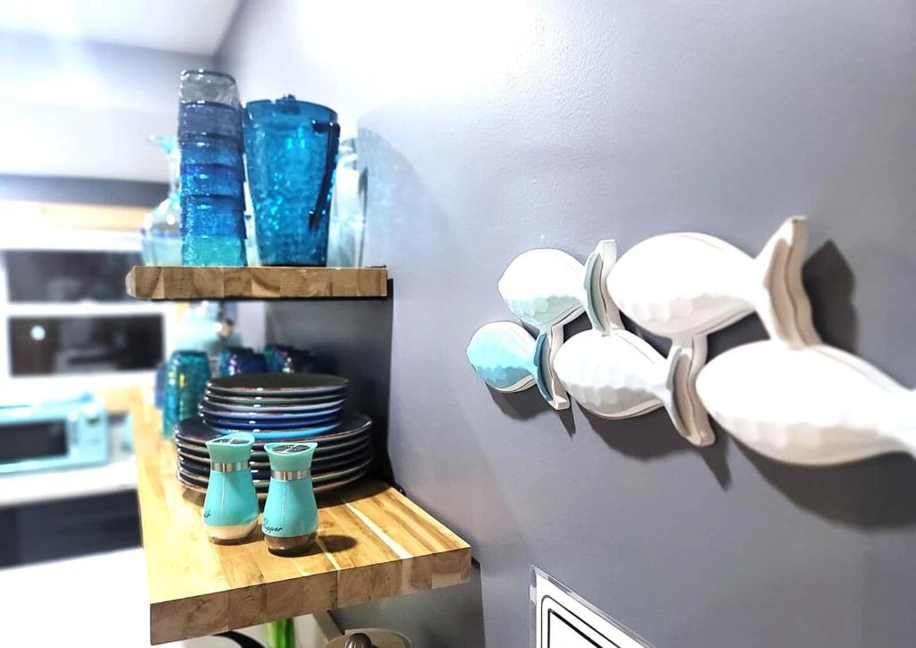 a kitchen with blue glasses and plates on a shelf at Sea & Sun Cottage #3 in Hampton