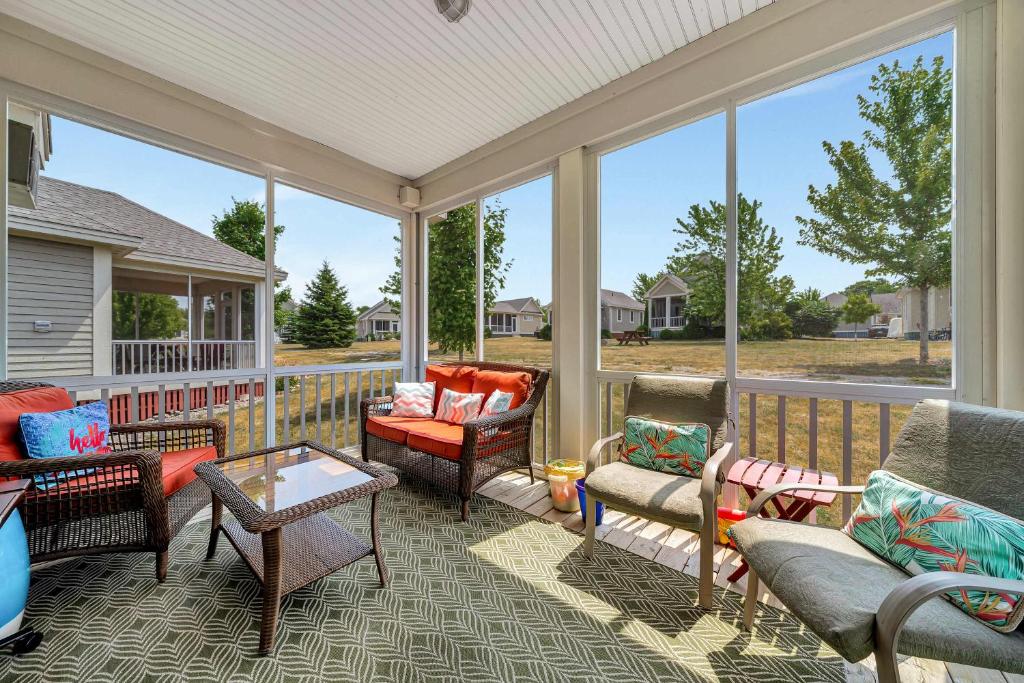 a screened in porch with furniture and windows at The Catbird - 28 Butternut in Cherry Valley