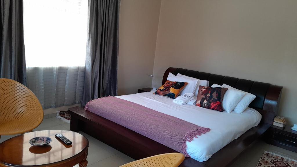 a bedroom with a bed with pillows and a table at Dulelo Serowe in Serowe